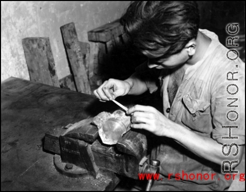 A Chinese worker repairs a piston by hand at an American base in China during WWII.