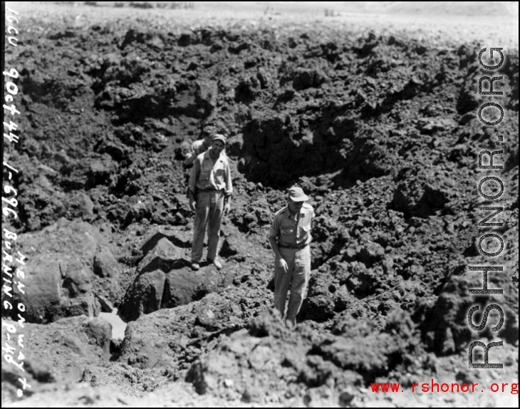 American GIs crossing bomb crater on their way to a burning P-40, October 9, 1944.  This is in Guangxi province, either Guilin or Liuzhou.