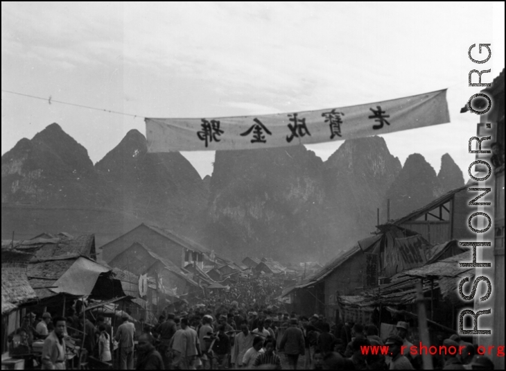 A crowded street in Liuzhou city, Guangxi province, probably just before the evacuation for Ichigo in the fall of 1944. The banner advertises a brand of product.