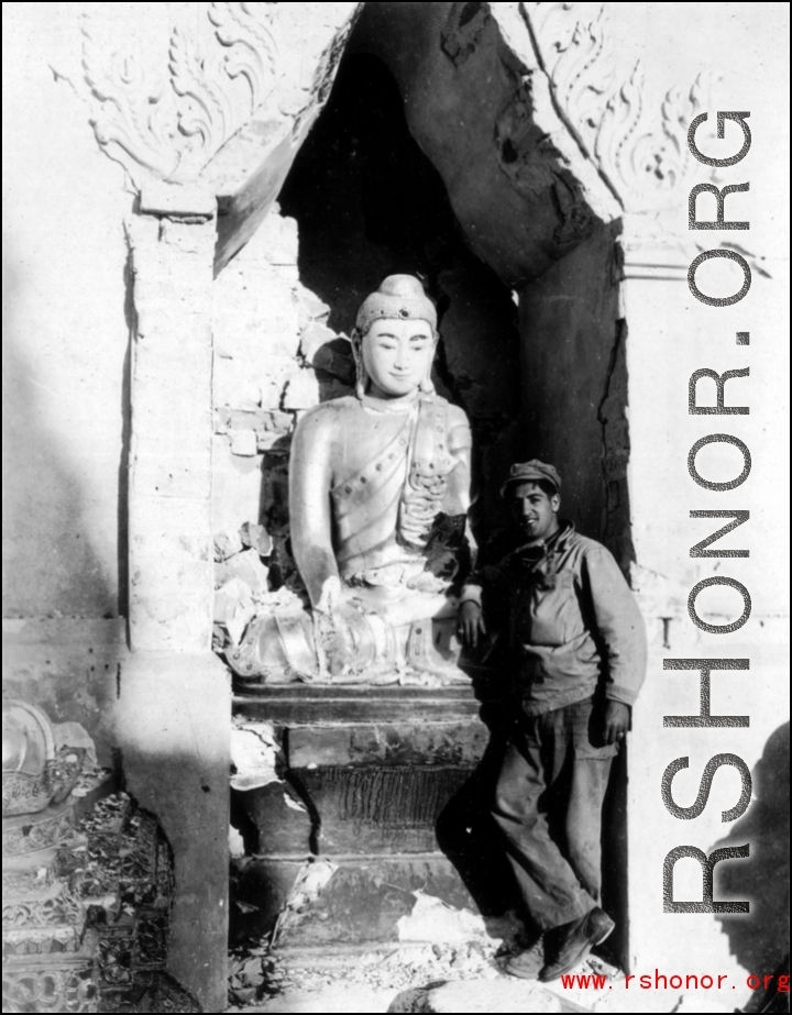GI poses with Buddhist statuette in the CBI during WWII.