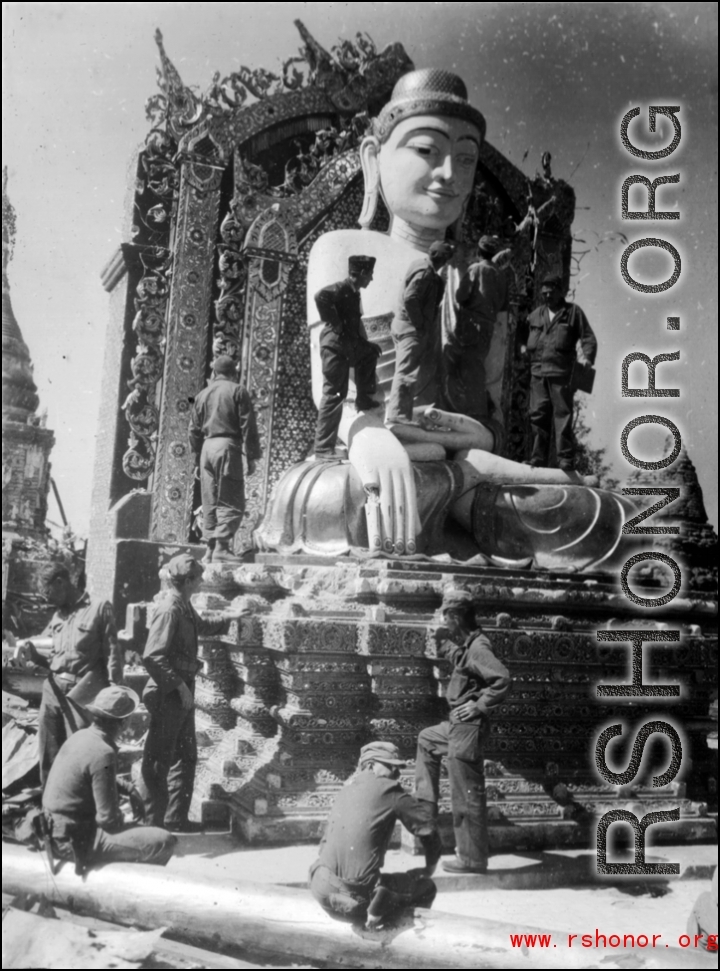 GIs examine Burmese Buddha statue in destroyed temple. During WWII.