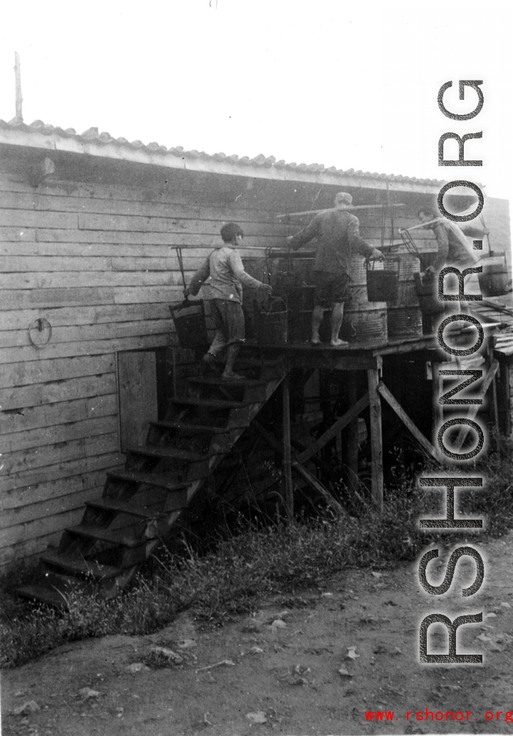 Laborers filling water cistern (of 55-gallon drums) at an American base in SW China during WWII.