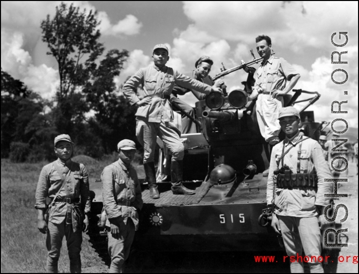 Chinese crew and American GIs aboard Chinese armored vehicle or tank pose for a photo. The vehicle was likely out on a large scale military exercise.  From the collection of combat photographer Eugene T. Wozniak, 491st Bomb Squadron.