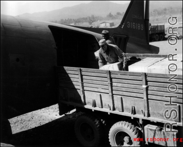 American servicemen load or unload supplies from a US transport plane.  Since, according the stories shared by veterans, African-American servicemen rarely made it into China, this must be outside of China, most likely India or Burma.