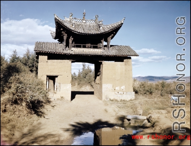 A decorative gate, strangely by itself, in the countryside somewhere in Yunnan province, China. During WWII.