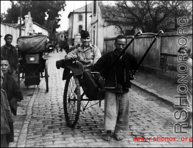 An American serviceman in the CBI riding a rickshaw pulled by a Chinese man.  From the collection of Wozniak, combat photographer for the 491st Bomb Squadron, in the CBI.