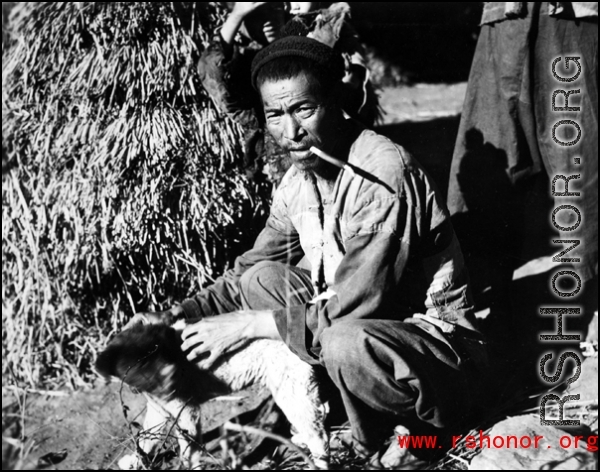 Local people  in China, probably in Yunnan province: A man in rural China with a dog.  From the collection of Wozniak, combat photographer for the 491st Bomb Squadron, in the CBI.