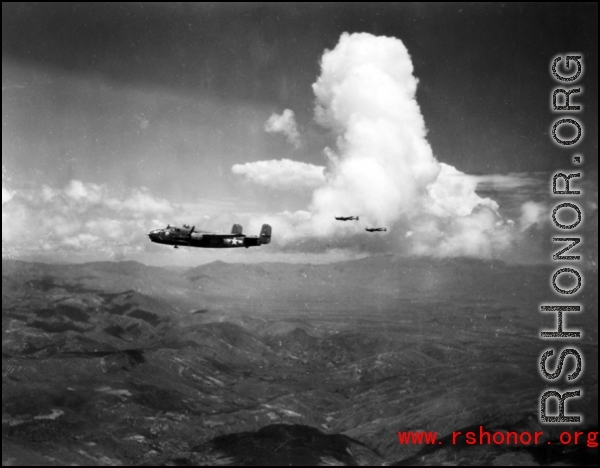 A 491st Bomb Squadron aircraft on a formation mission in China, #439, "Rum Runner." It was destroyed in a crash landing at Liuzhou in June 1944.  Two more aircraft are silhouetted against the cloud in the background. They  appear to also be B-25s, however, we are unable to identify  whether they are also 491st or aircraft from the 11th Bm Sq.  Planes from both squadrons flew many joint missions from February 1944 until the summer of 1945.