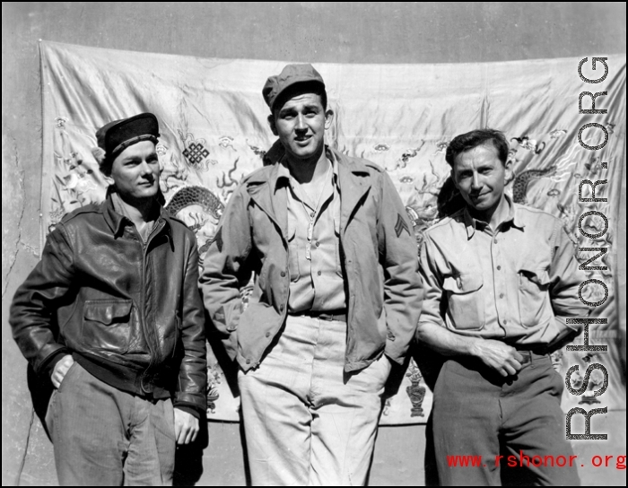 GIs in the CBI, standing in front of an elaborate embroidered silk sheet, during WWII.