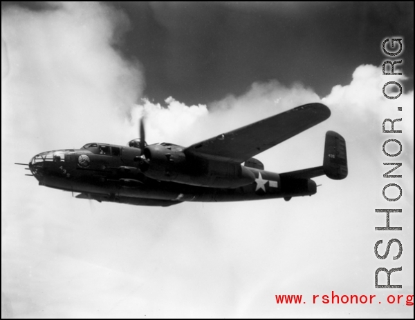 491st Bomb Squadron aircraft #438, a B-25J appears smooth in formation flight in spite of large, turbulent clouds filling the China sky behind it. Notice the barrels of three .50 caliber machine guns sticking out of the nose of the aircraft. One is a flexible gun, used by the bombardier or navigator to defend the nose from attack.  The other two are hard mounted to the lower, right side of the bombardier's area. The pilot fires them simultaneously with four mounted to the sides of the aircraft for straffing