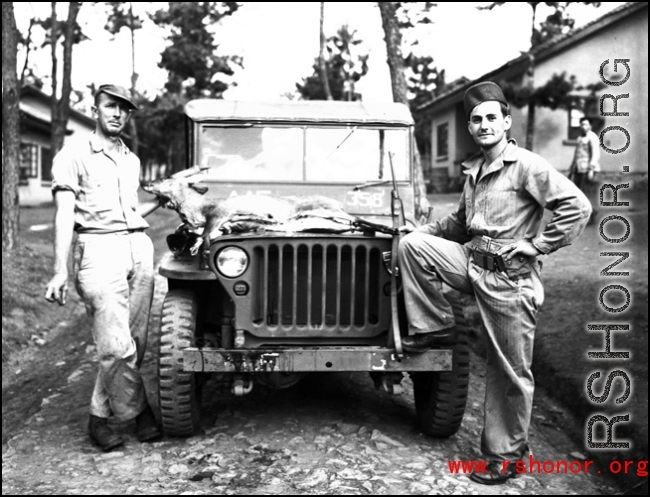 American GIs in China during WWII, with a carbine and the small animal they have hunted on their jeep.
