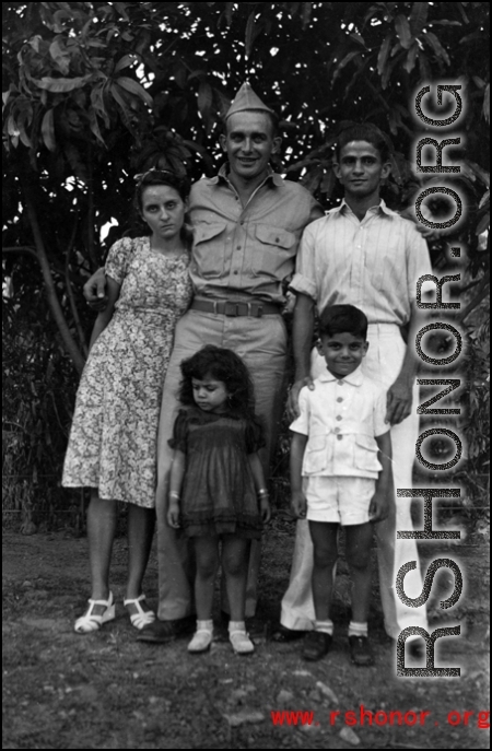 A GI poses with a young family. People in the CBI.