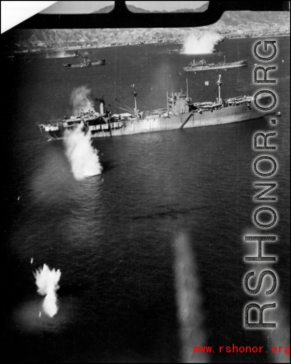 Photo from a B-25 Mitchell running right over a Japanese ship very low during a raid on Hong Kong. Notice bombs in the air on the left, and blurred outline of the plane's twin machine guns in the foreground (presumably this photo is through the tail gunner's window). The separate B-25 that is dropping those bombs is outlined in shadow on the water at the end of the guns.  From a mission on Hong Kong, 491st Bomb Squadron.