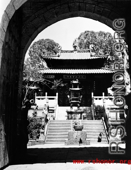 The central courtyard of local Buddhist temple in  China, probably in Yunnan province, with large bronze incense burner. During WWII.