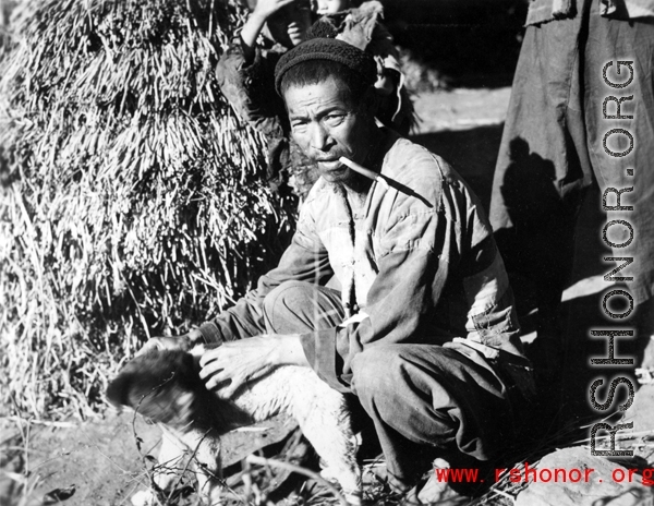 Local farmer in China, in Yunnan province, near Yangkai, with a small dog. During WWII.
