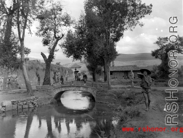 A small bridge near a town wall, with local people  in Yunnan province, China.  From the collection of Eugene T. Wozniak.
