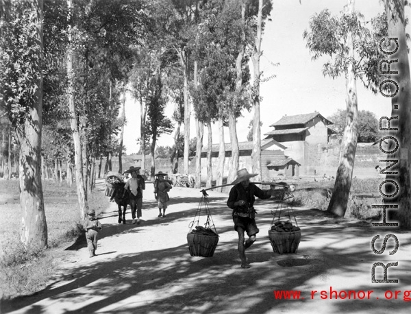 Local people walking near a village in Yunnan province, China. During WWII.