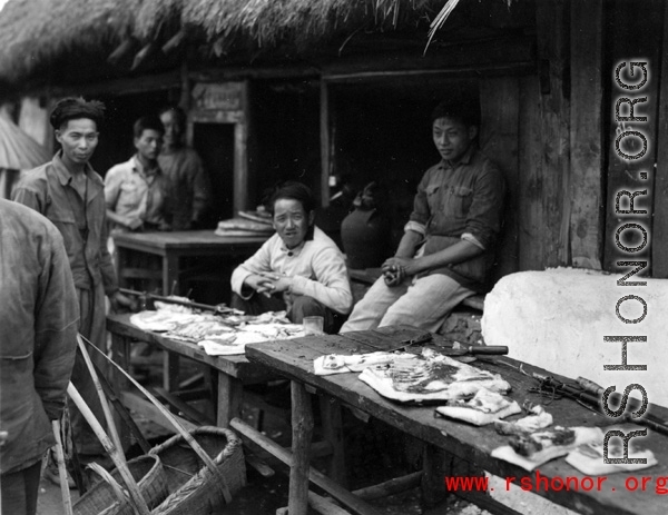 A pork seller in a village market in Yunnan province, China. During WWII.