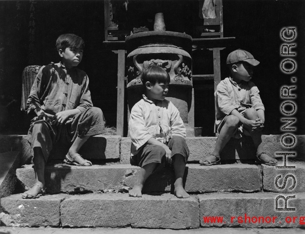 Local people in China: Chinese boys sitting before incense burner. During WWII.