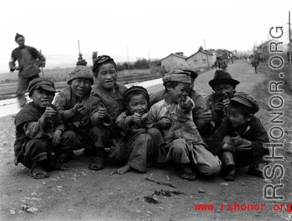 Local kids roadside in China give a 'ding hao' thumbs up during WWII.  From the collection of Eugene T. Wozniak.