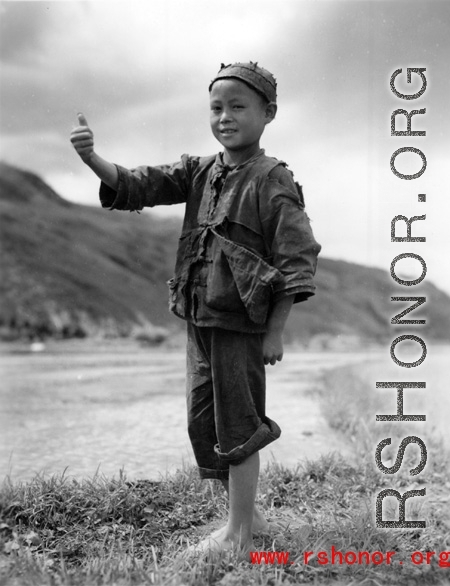 Local boy in China give sa 'ding hao' thumbs-up to the photographer during WWII.