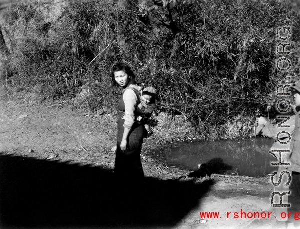 A woman carries a baby on her back in Yunnan province, China, during WWII.
