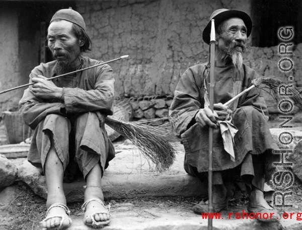 Men smoking pipes in a village in Yunnan, China, during WWII.