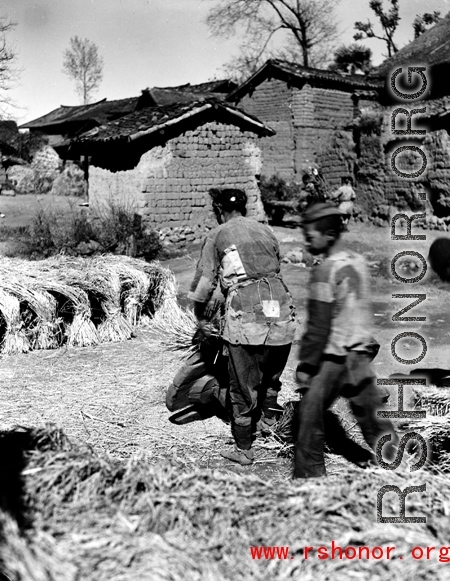 People in a local village in Yunnan province, China, threshing grain by striking the rice straw against old wooden wheels. During WWII.