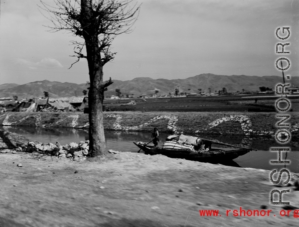 Local people and boat in near Kunming, China, during WWII.