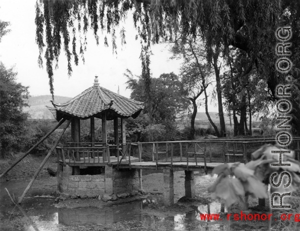 Local scene in Yunnan province, China: A small pavillion over a dried pond in a Chinese town.