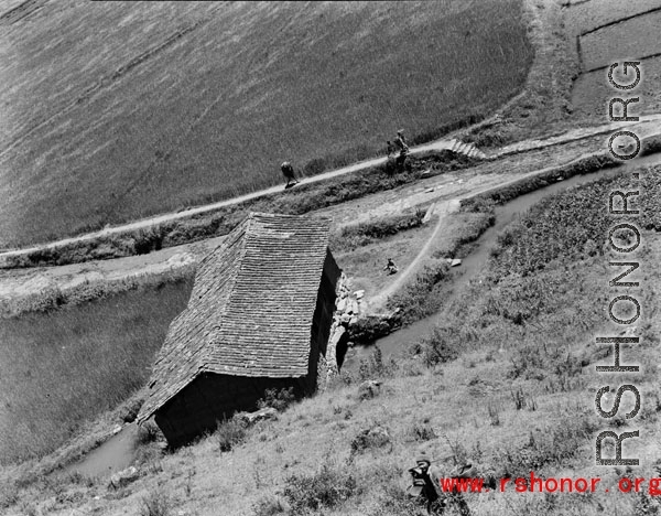 An apparent mill house over a canal, and farmers walking path, in Yunnan province, China, during WWII.  From the collection of Eugene T. Wozniak.