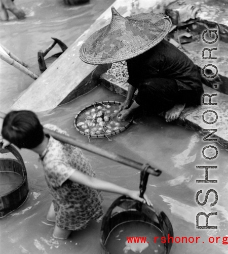 Local people washing vegetables  in Liuzhou city, Guangxi province, China, during WWII.