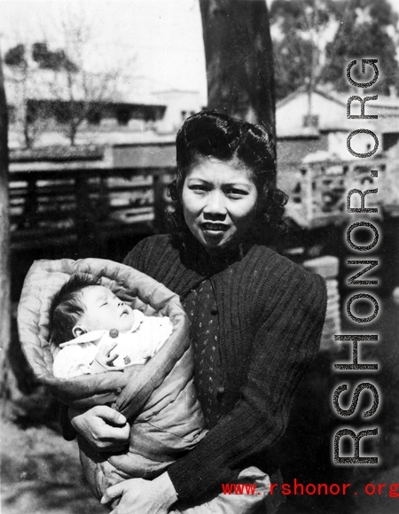 An urban Chinese woman holds a baby during WWII. Local people in Yunnan province, China.