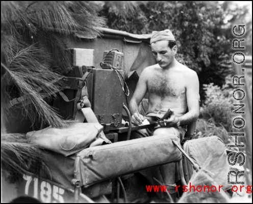 During WWII in China, an American GI operates a portable radio from the back of a vehicle in near Guilin, Guangxi province.