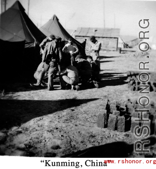 A handful of GIs huddle at a tent city at a base near "Kunming, China" during WWII.