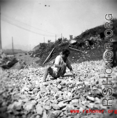 A worker crushing rock by hand at a base in southwest China, during WWII.