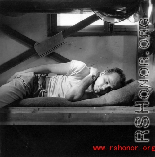 Barracks life at an American base in southwest China during WWII: GI lies pensively on his bunk. 