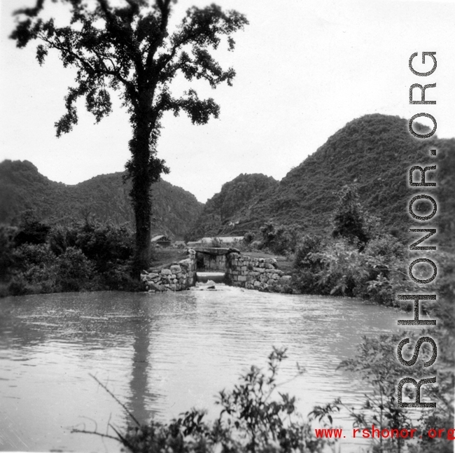 Scenery, including a canal or other water work, in southwest China, either Guangxi or Guizhou province, during WWII.