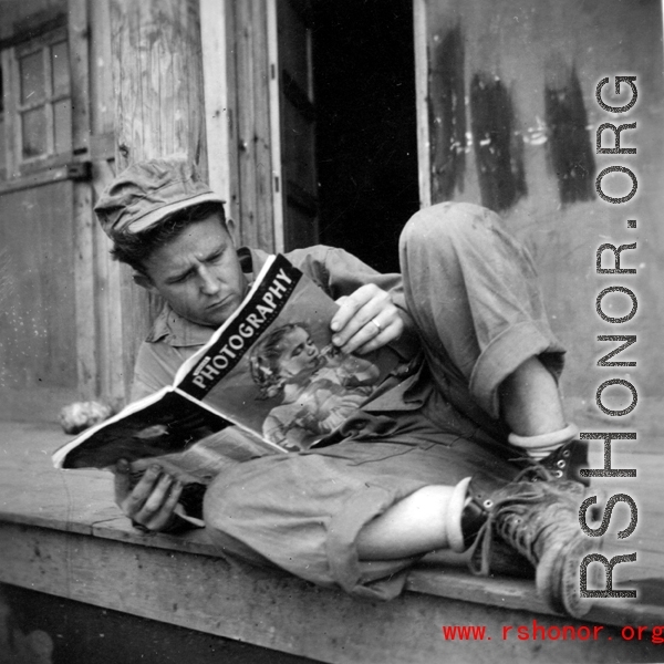 GI reading a Photography magazine at an American installation in the CBI, during WWII.