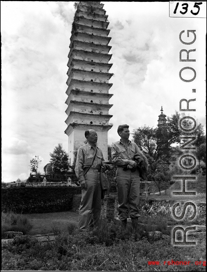 Two American servicemen in SW China area standing in front of pagoda.  Note that the one on the left is a chaplain.