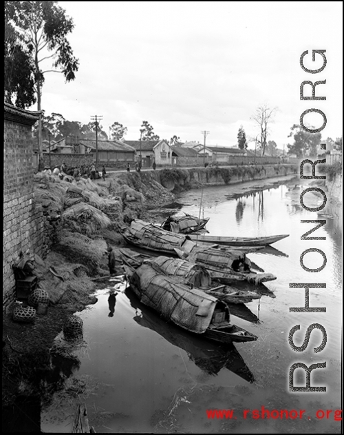 Boats in a canal in Yunnan province, China, possibly near Kunming, during WWII.
