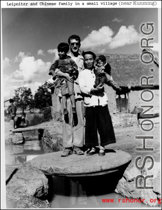 T/5 C. W. Leipnitz and a Chinese family pose together is a small village near Kunming, China, during WWII.