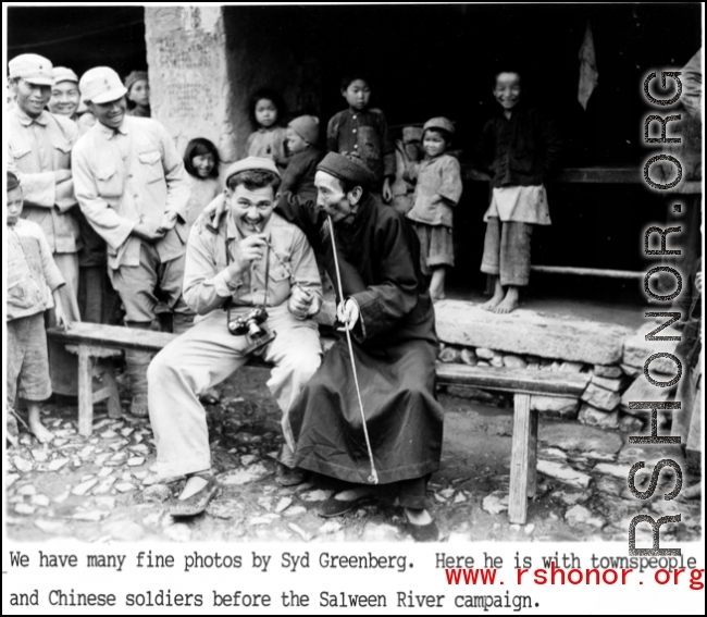 Photographer and funny man Syd Greenberg tries out a long pipe with a local Chinese gentleman, and soldiers and kids look on with enthusiasm, before the Salween River campaign. 