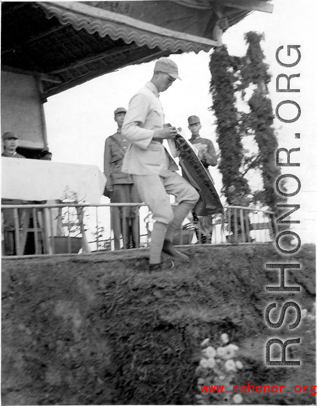 Chinese soldier of the 48th Army Division (陆军第四十八师) gets banner in a ceremony as part of a shooting contest ("射击比赛")  during a rally.