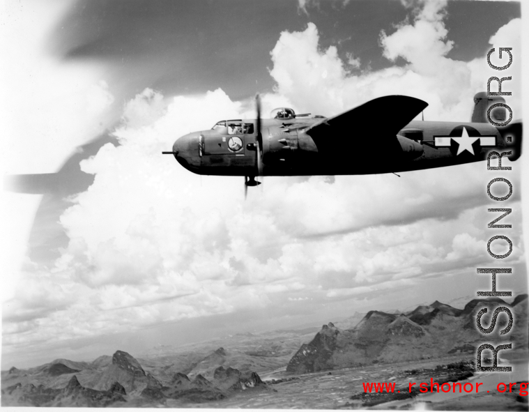 B-25 Mitchell bomber surges forward in flight over limestone karst mountains, in the area of southern China, Indochina, or Burma.