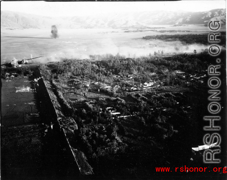 Smoke arises from city wall after attack by B-25 Mitchell bombers during battle with Japanese ground forces, flying over Tengchung (Tengchong), near the China-Burma border in far SW China.