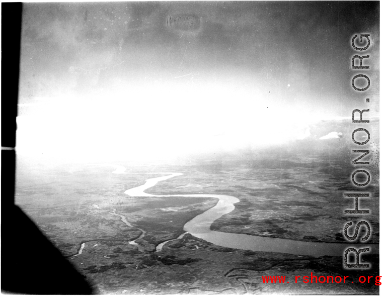 An image of a river and the ground as seen from a B-25 Mitchell, in SW China, or Indochina, or the China-Burma border area.