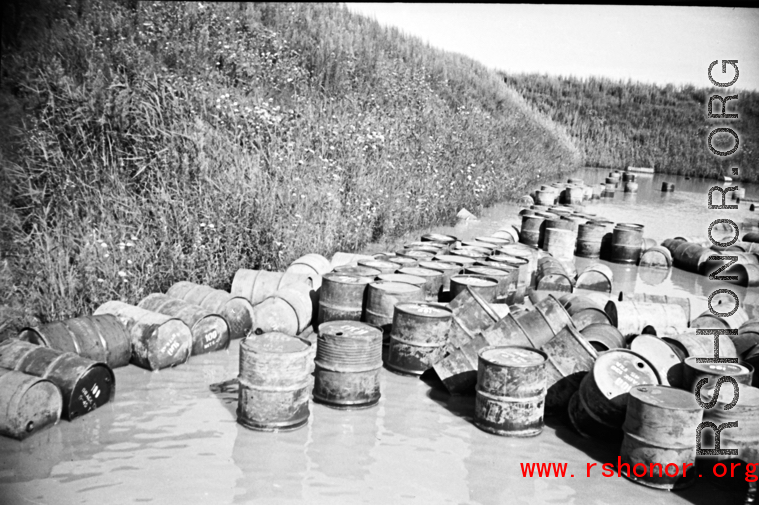 Fuel barrels in a flooded revetment in Yunnan province, China, most likely at the Luliang air base area. During WWII.
