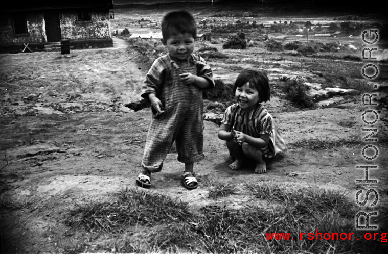 A boy and girl playing in Yunnan, China, near an American air base. During WWII.