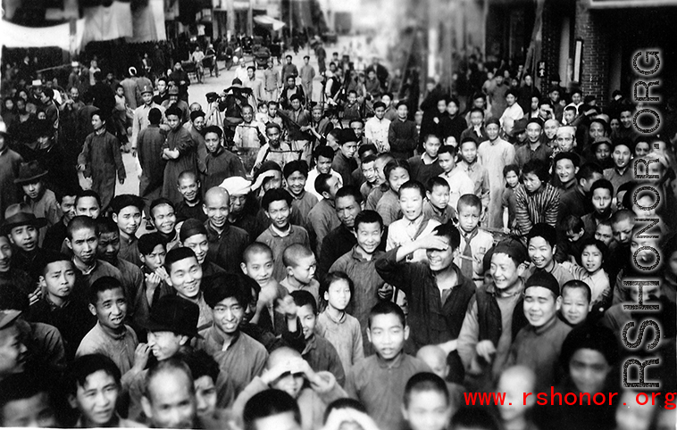 A wonderful image from the Walter S. Polchlopek collection--a local crowd, probably in the county seat not far from Yangkai (Yangjie) air base in Yunnan province, China, enjoying the entertainment of inscrutable foreigners doing funny things in public, that is, they are enjoying the public goofing around by the photographer who is stand raised above the crowd, maybe simply on an American jeep (as in the entry here).  Some expressions (below) really speak to the nature of the interaction.